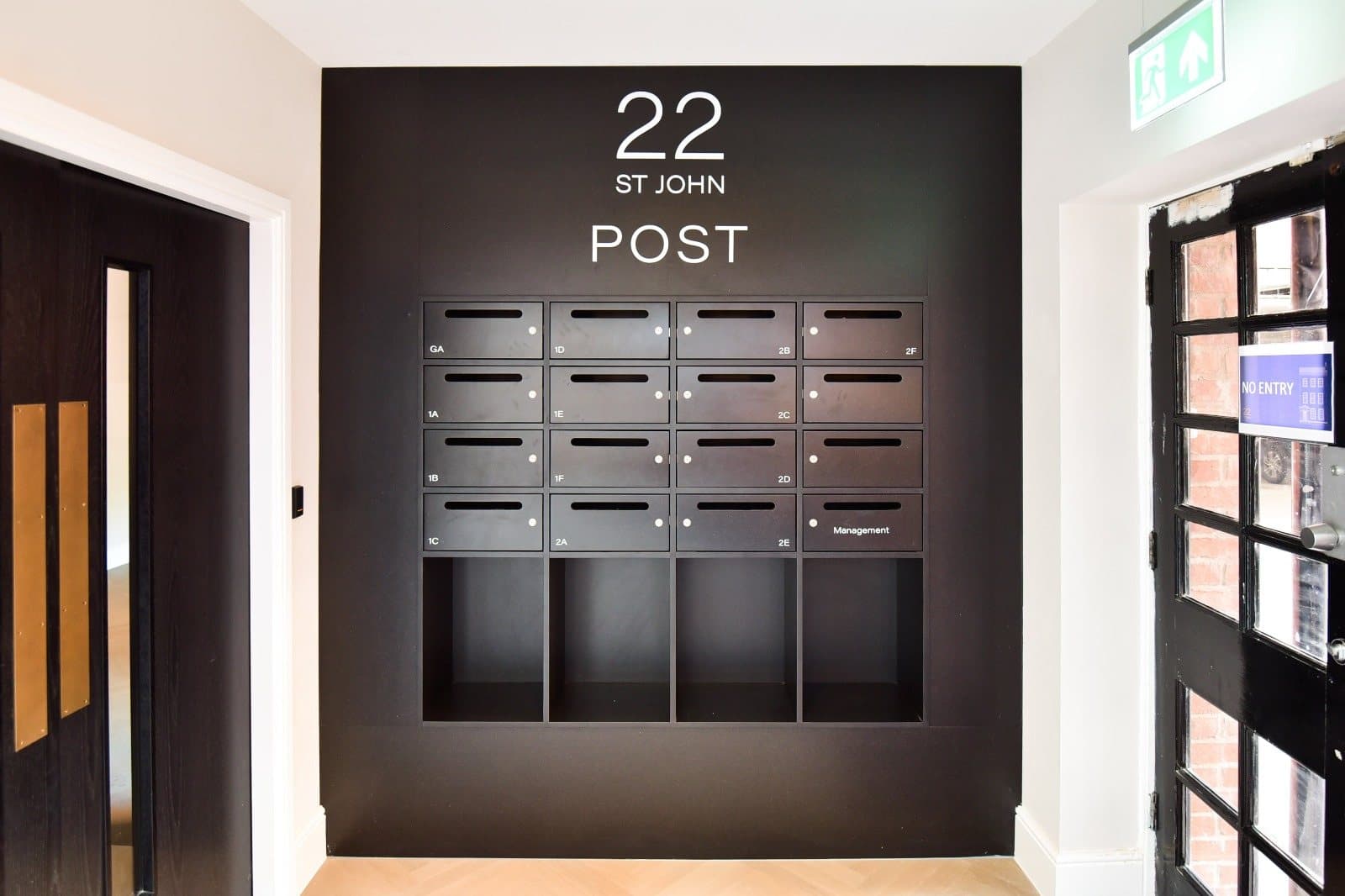 Post room with brass-numbered mailboxes for every suite
