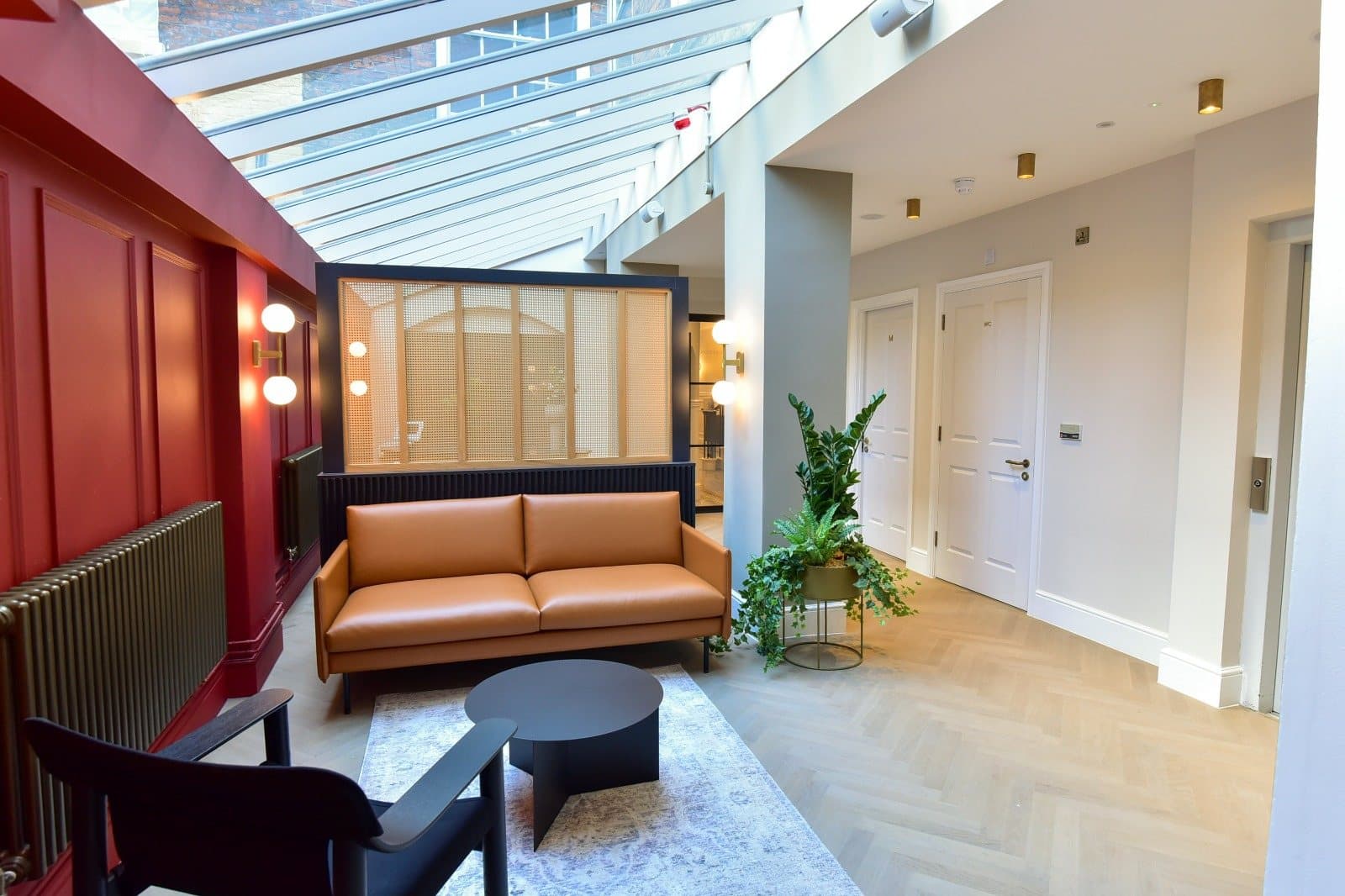 Atrium lounge with deep red panelling and tan leather seating