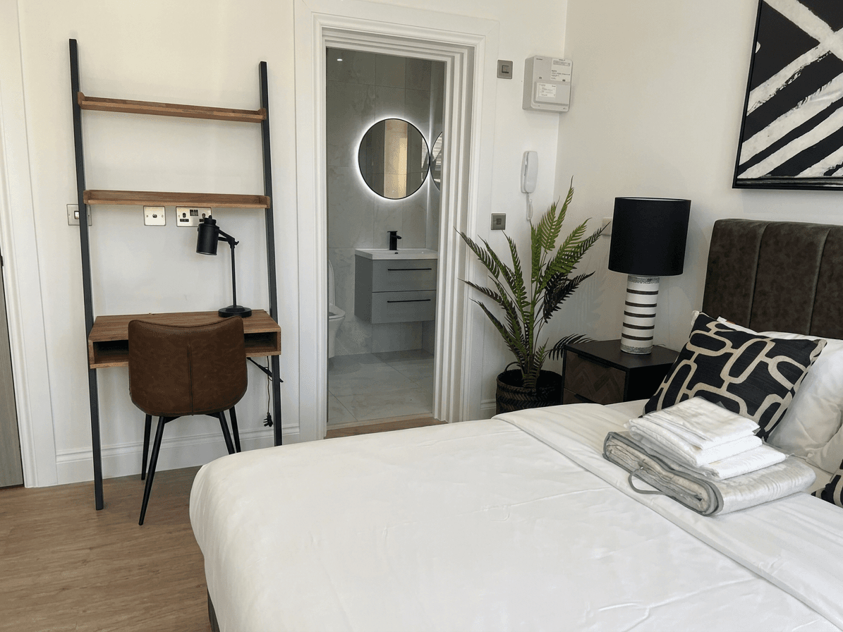Desk, shelving and shower room in an en-suite room