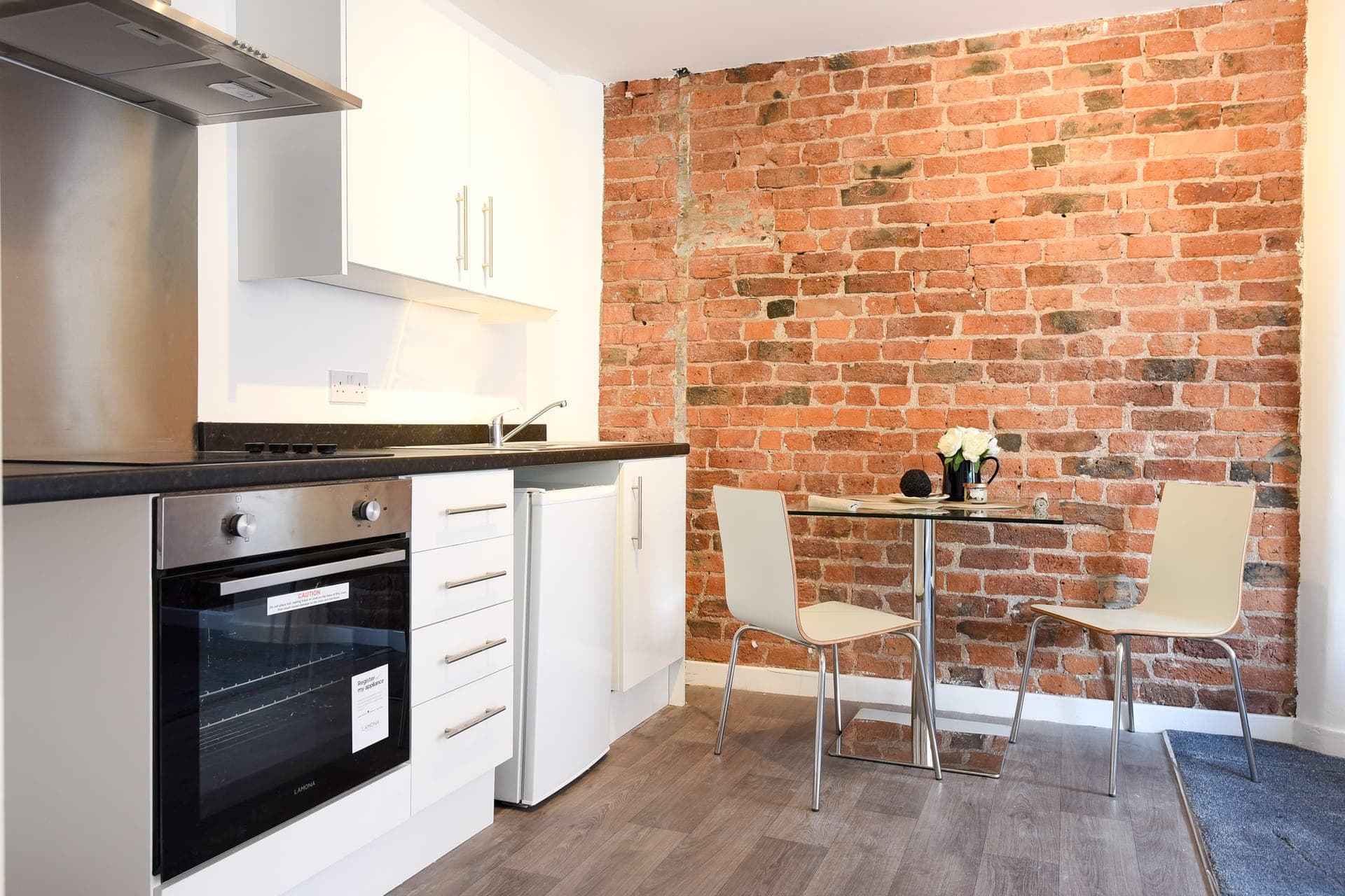 Kitchenette and dining table against the exposed brick