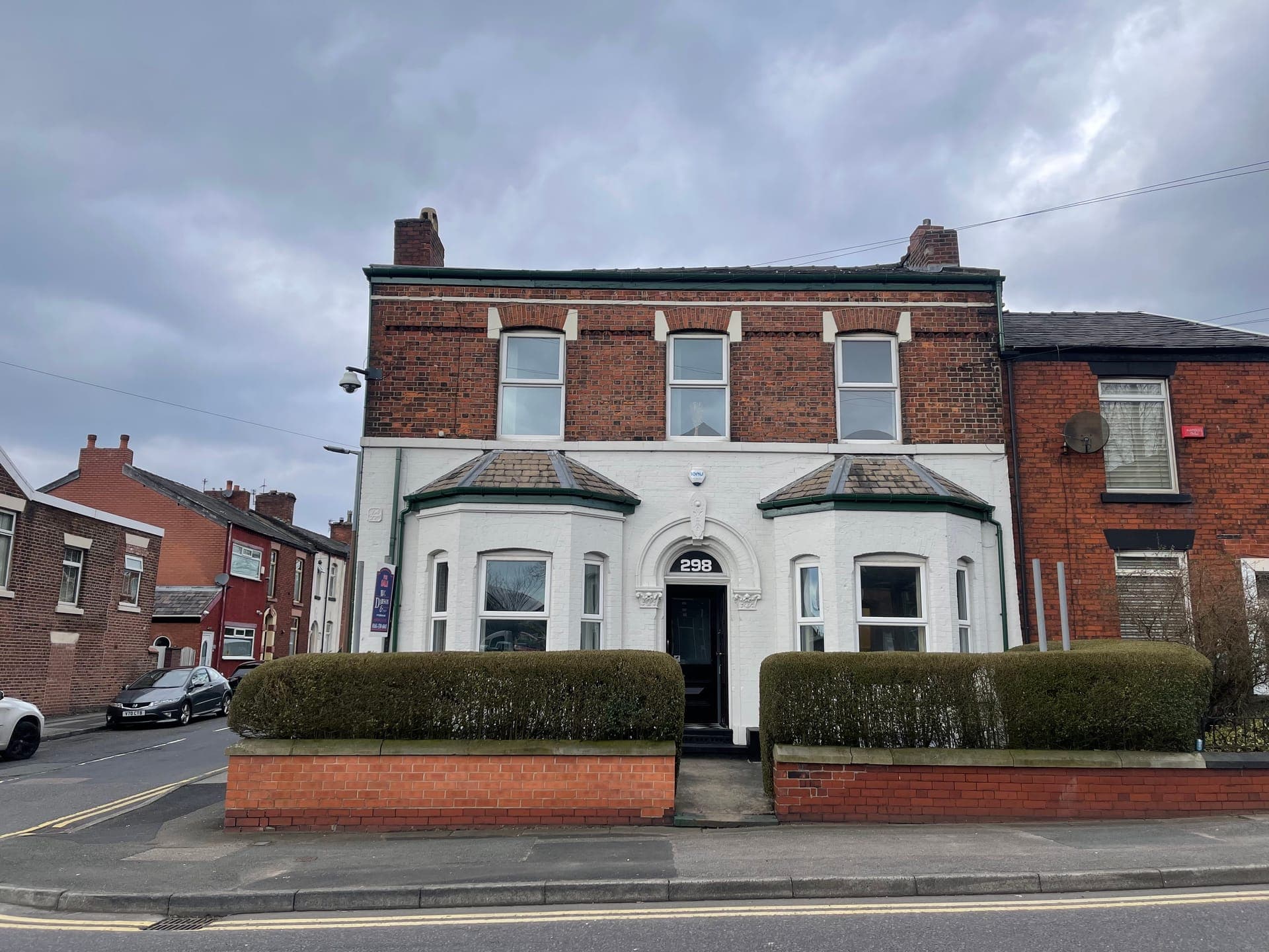 The painted brick frontage with its twin bay windows