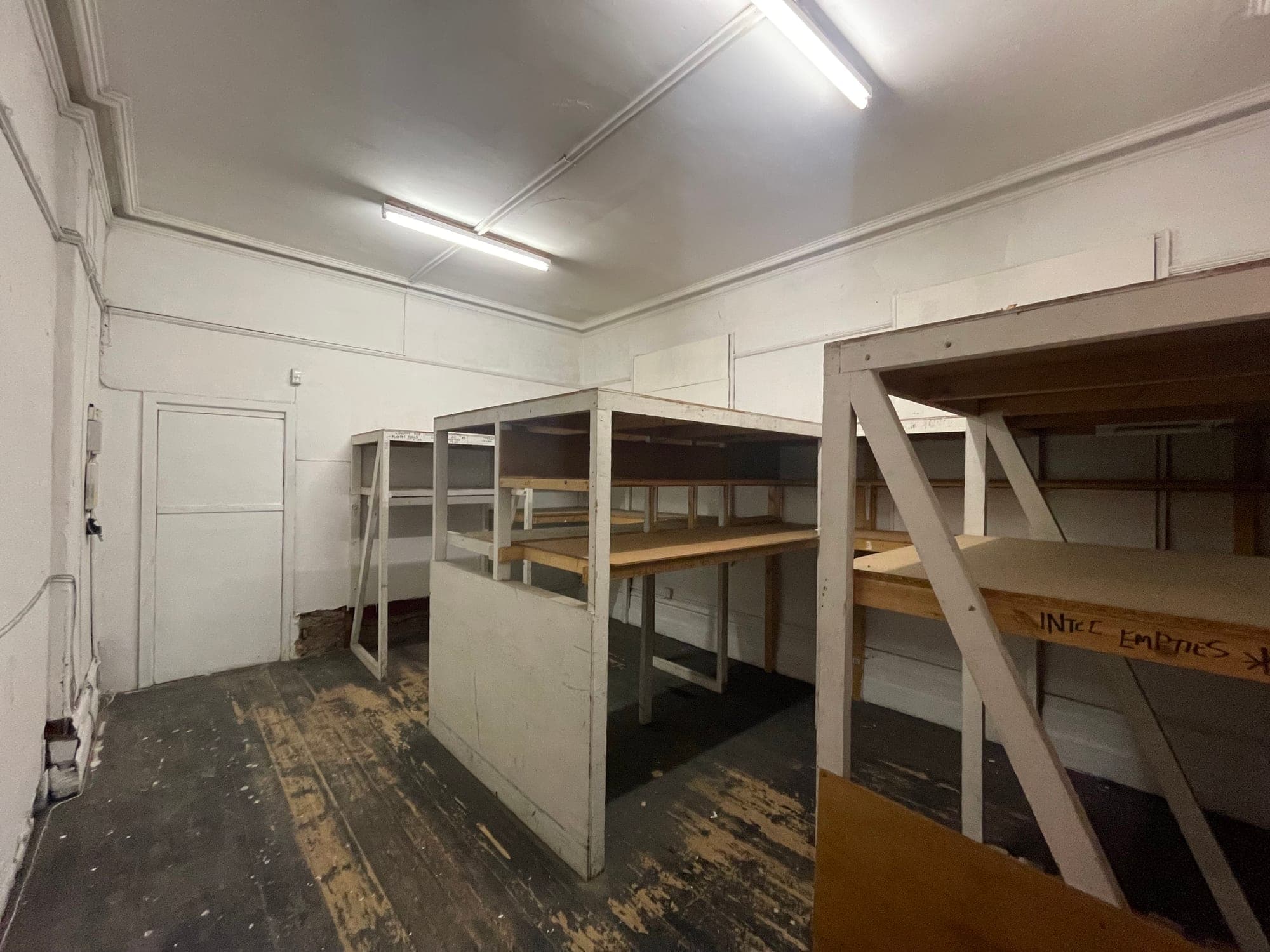 Timber staging and bare boards in a stripped-back room